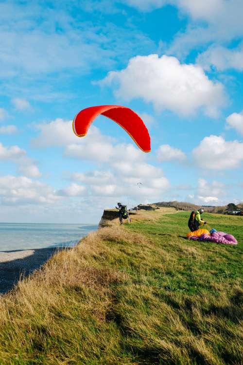 Person On A Grassy Hill With A Red Kite Photo