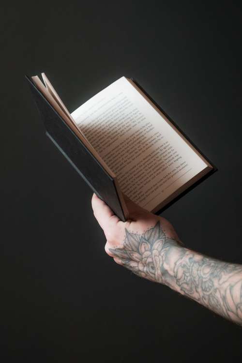 Hand Holds Out An Open Book Photo