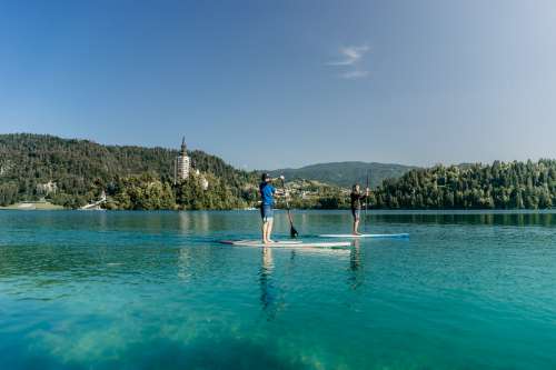 Two Paddleboarders On Aqua Blue Water Photo