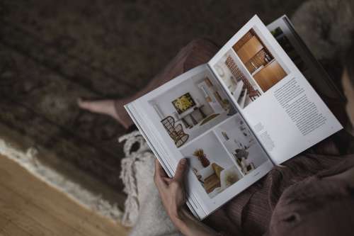 Person Holds An Interior Design Book On Their Lap Photo