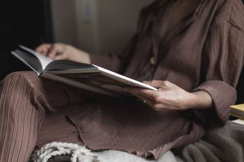 Person Relaxing Reading A Large Coffee Table Book Photo