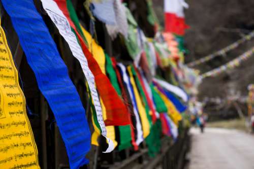 Some Colorful Flags Line A Fence Photo