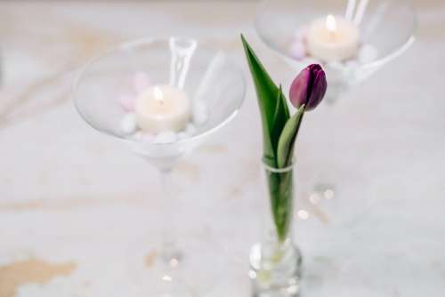 Table candle decoration with a purple tulip