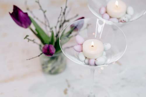 Table candle decoration with purple tulips