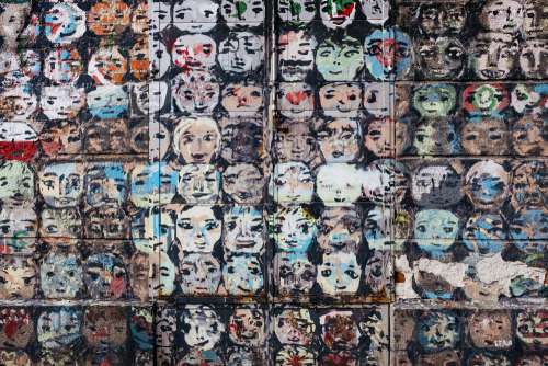 Graffiti of many cartoonlike faces on a building
