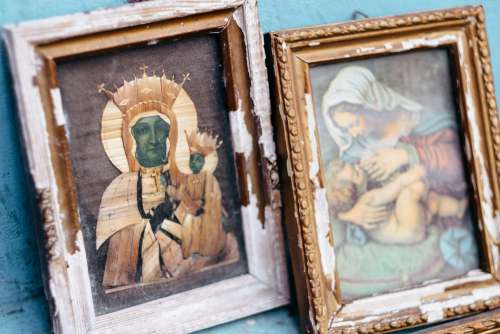 Distressed catholic holy pictures placed outside a poor neighbourhood closeup