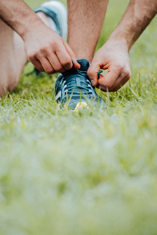 Hands Tying Shoe Laces On A Running Shoe Photo