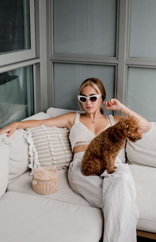 Woman In Cateye Sunglasses Sits With A Puppy Photo