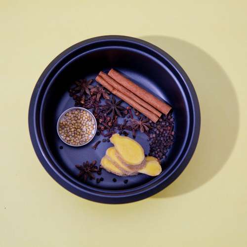 Spices Lay In A Blue Bowl Against A Yellow Background Photo