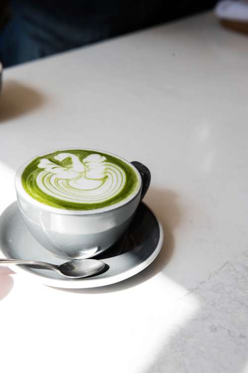 Matcha Latte In A Grey Mug On A White Table Photo