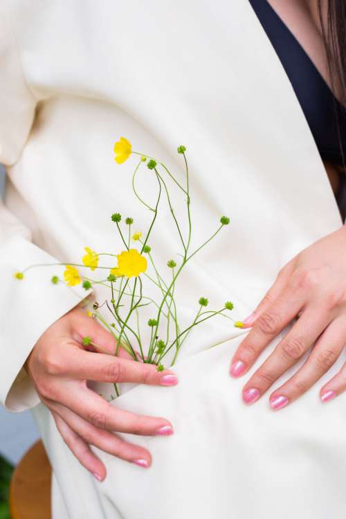 Hands Holds Buttercup Flowers In The Pocket Of Their Coat Photo