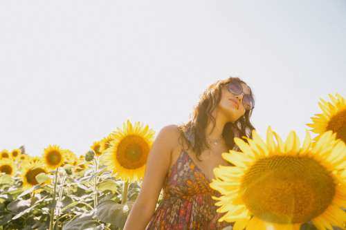 Woman In A Floral Dress Surrounded By Sunflowers Photo