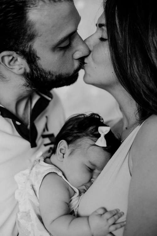 Black And White Photo Of Parents Holding A Baby Photo