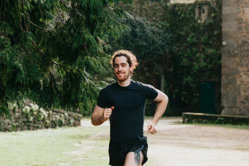 Man In Black Out For A Run Through Green Trees Photo