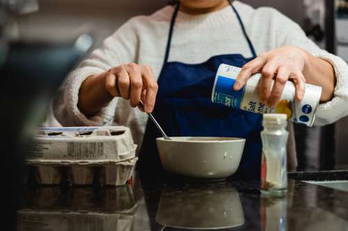 Person Stirs A Bowl And Holds Salt To Pour Photo