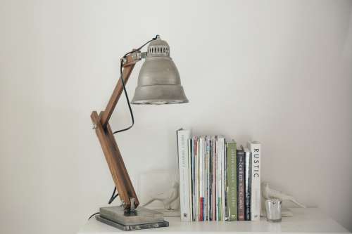 Silver Lamp On A White Table Next To Books Photo