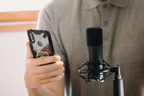 Person In Front Of Microphone Holding Their Cell Phone Photo