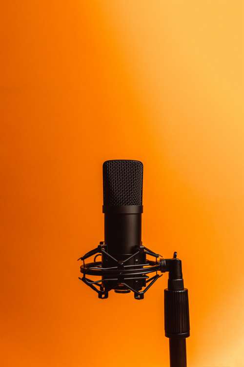 Black Microphone Against Orange Photo Photo