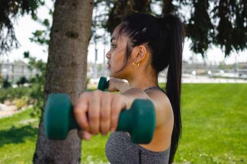 Profile Of A Woman Who Is Holding Hand Weights Outdoors Photo