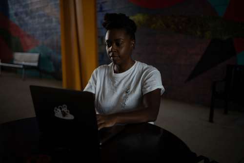 Woman Sits And Works On An Open Laptop Photo