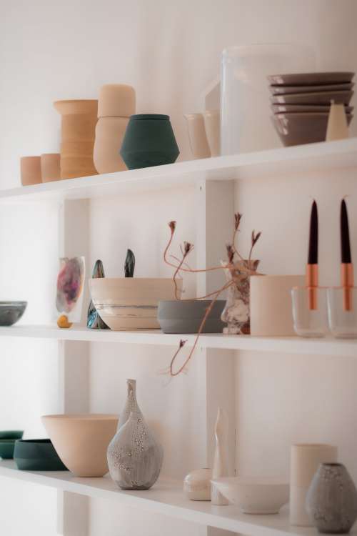 White Shelves Filled With A Variety Of Pottery Photo