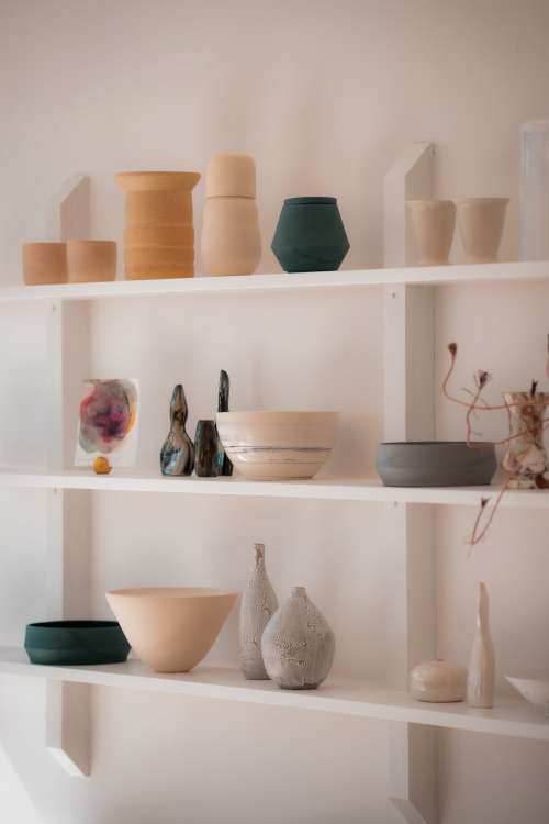 Photo Of White Shelves Filled With Pottery Photo
