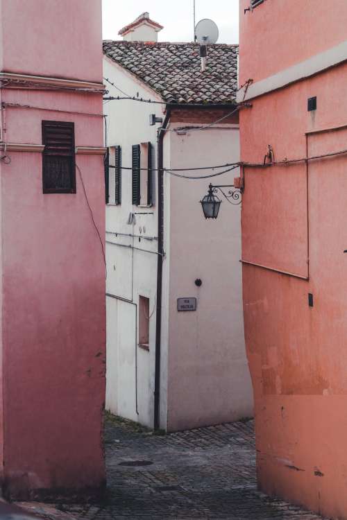 A White Building Between Two Pink Buildings Photo
