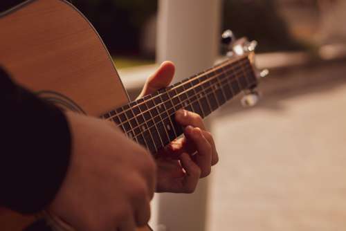 Close Up Of Hands Playing An Acoustic Guitar Photo