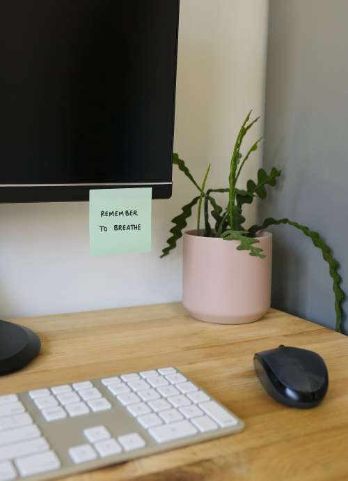 Desk With A Reminder To Breath On The Monitor Photo