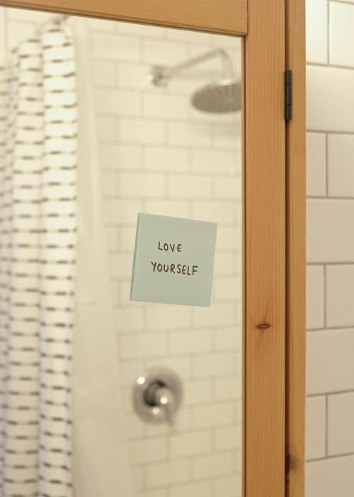 Blue Note On A Bathroom Mirror Reads Love Yourself Photo