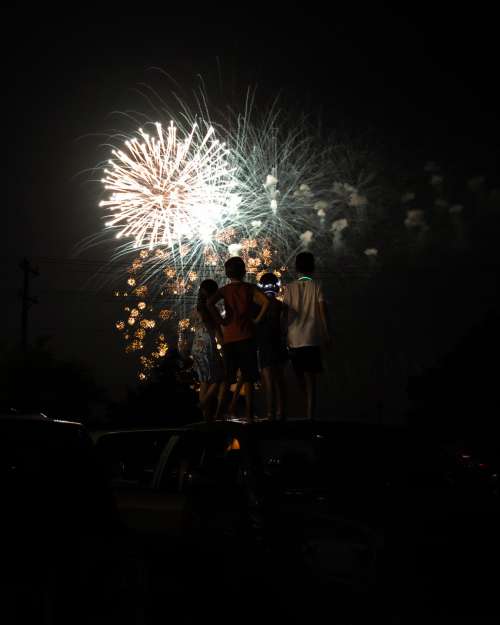 People Stand Together And Watch The Fireworks Overhead Photo