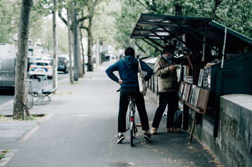 Person On A Bike Waits For Their Friend To Shop For Books Photo