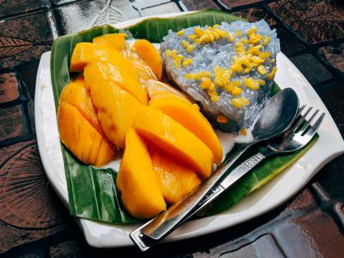 White Plate With Mango Rice And Cutlery Photo