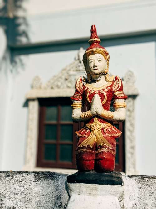 Red And Gold Statue Of A Person Praying Photo