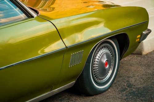 The Front Side Of An Olive Green Classic Car Photo