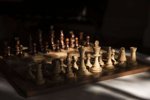 Wooden Chess Set In Partial Window Light Photo