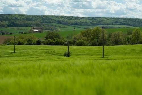 Green Rolling Hills And A Small Building In The Distance Photo
