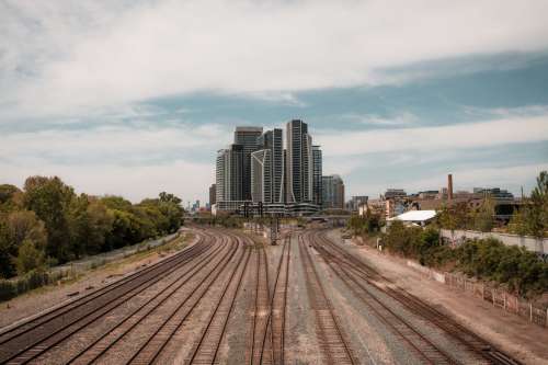 Train Tracks Split Where Tall City Buildings Stand Photo