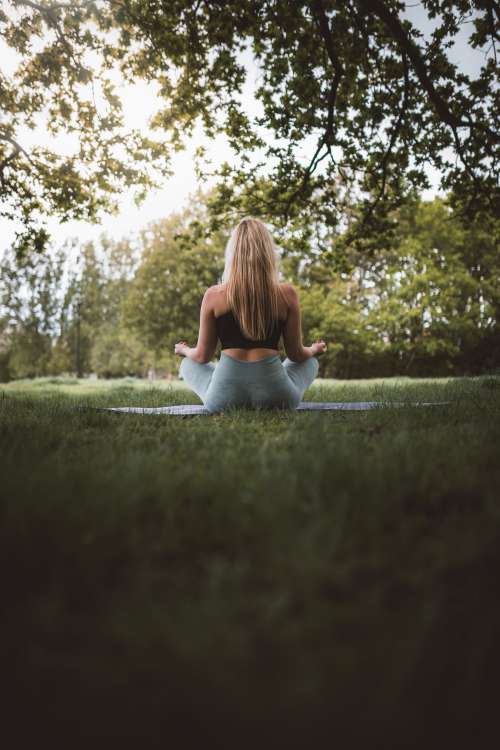 Back Of A Woman Sitting Outdoors On A Mat Photo