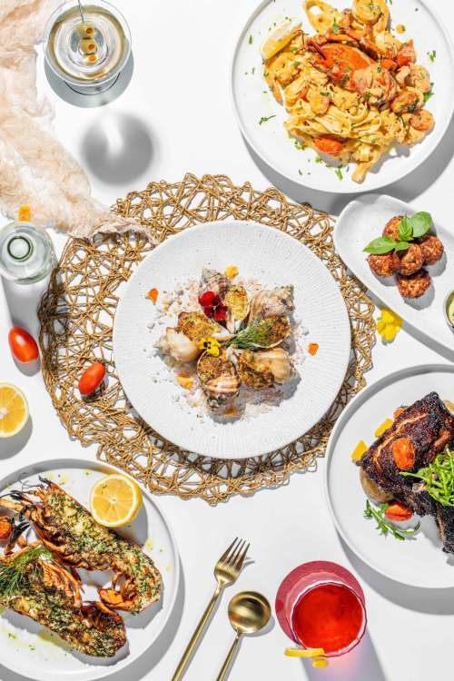 Flatlay Of Varied Plated Food On White Plates Photo