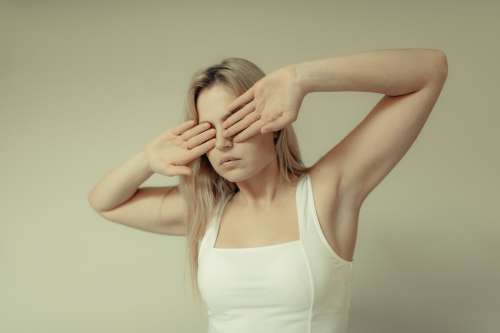 Woman Stands And Covers Her Eyes With Her Palms Outwards Photo