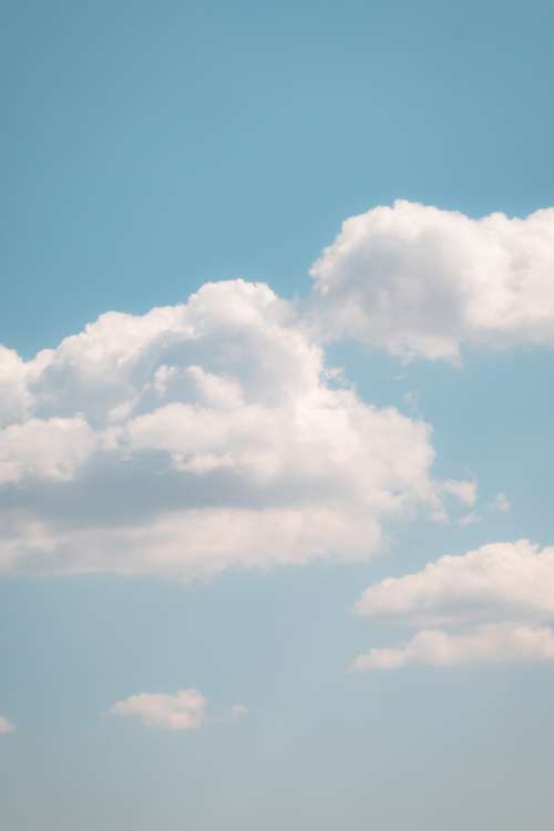White Clouds In A Soft Blue Sky On Warm Summer Day Photo