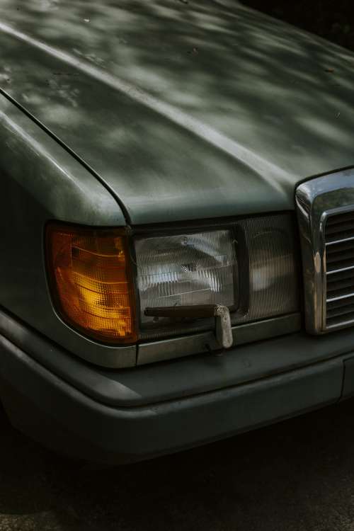 The Front Headlight Of A Dark Green Car Photo