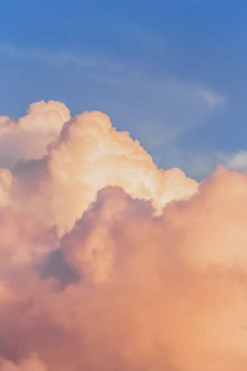 Fluffy Clouds Are Colored By A Setting Sun Photo