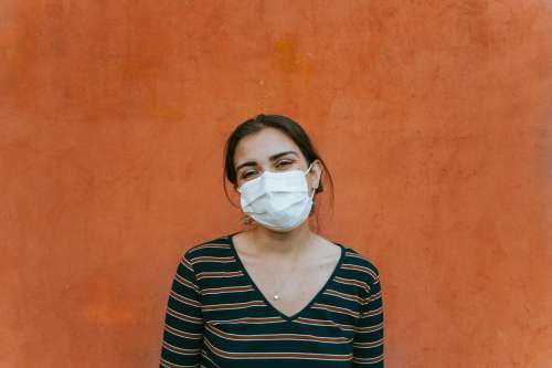Smiling Person In A Facemask By An Orange Wall Photo