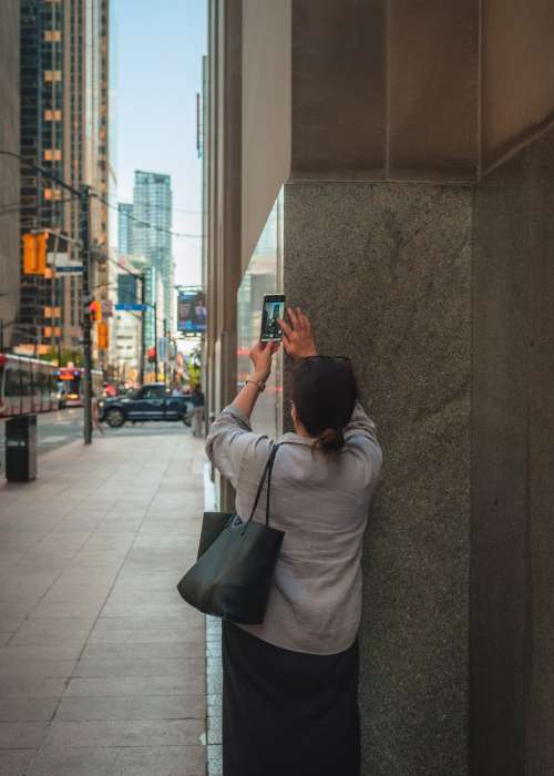 Person Uses Their Cell Phone To Talk A Picture Of A Building Photo