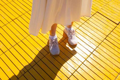 Person In White Stands On A Yellow Surface Photo