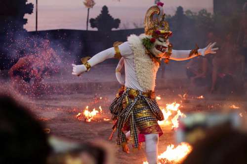 Person With A Fluffy Mask Dances Around Fire Around Them Photo