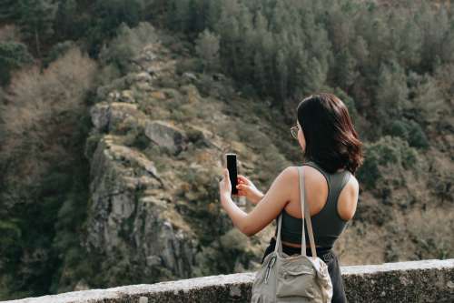 Woman Holds Her Cellphone Out To Take A Picture Outdoors Photo