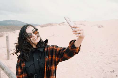 Woman In Sunglasses Takes A Selfie At The Beach Photo